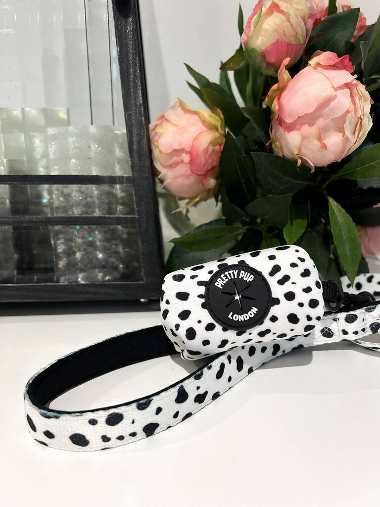 handle of a dalmatian print dog lead with the matching dalmatian print dog poo bag dispenser