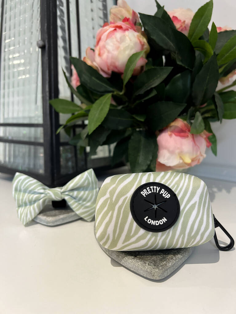 zebra print dog poo bag dispenser with matching green dog bow tie in the background