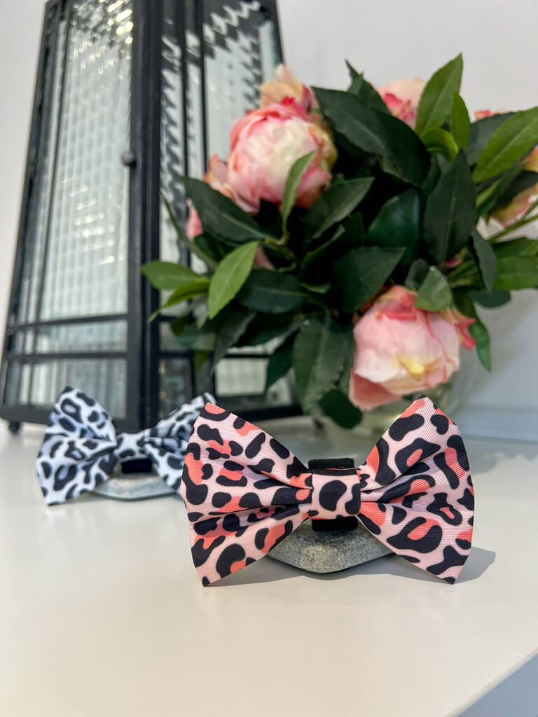 two dog bow ties next to eachother, one in orange leopard print and the other in grey leopard print